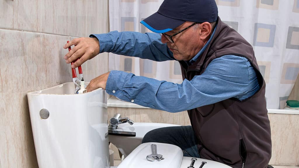 Homeowner performing a simple leak repair in a bathroom.