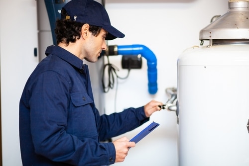 A plumber repairs a water heater